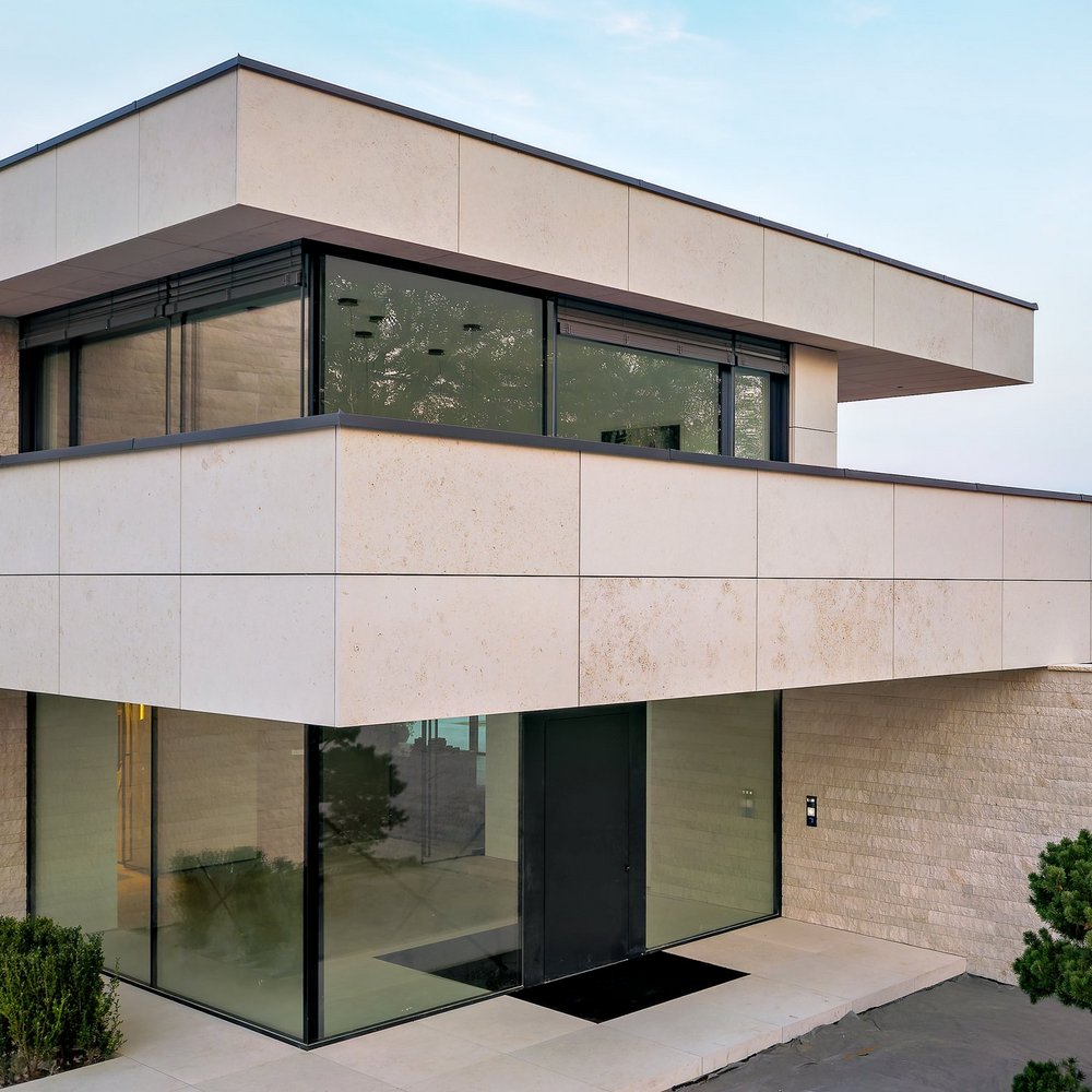 Die sandgestrahlte Kalksteinfassade bildet fließende Übergänge zwischen Innen- und Außenräumen